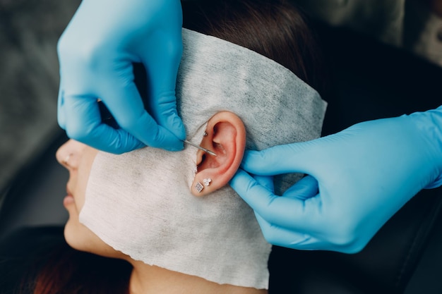 Jonge vrouw die piercing doet bij schoonheidssalon?