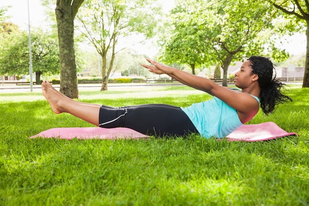 Jonge vrouw die pilates op mat doet