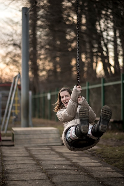 Jonge vrouw die pret op een schommeling heeft