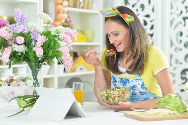 Jonge vrouw die salade bereidt