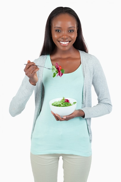Jonge vrouw die salade eet