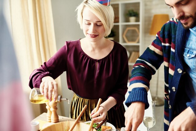 Jonge Vrouw die Salade maken bij Partij