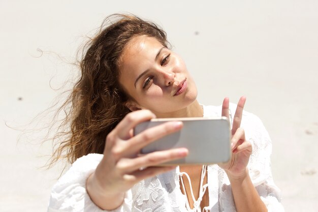 Jonge vrouw die selfie met mobiele telefoon nemen