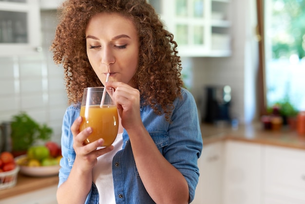 Jonge vrouw die sinaasappelsap drinkt