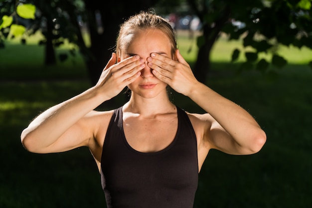 Jonge vrouw die sportkleding in het park draagt