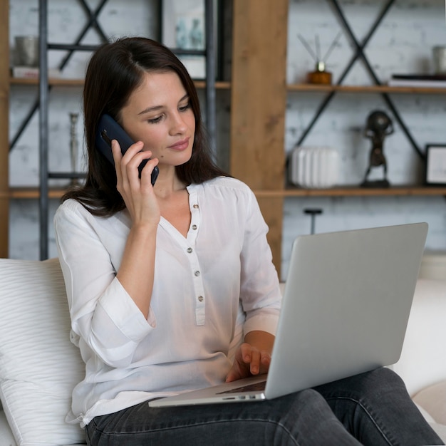 Foto jonge vrouw die thuis aan haar laptop werkt