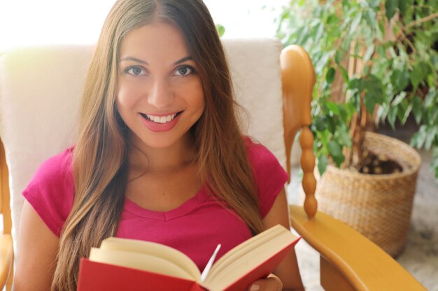 Jonge vrouw die thuis een boek leest