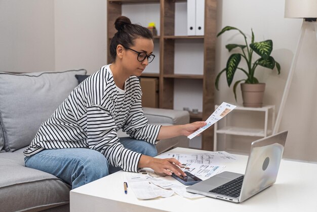 Foto jonge vrouw die thuis een laptop gebruikt