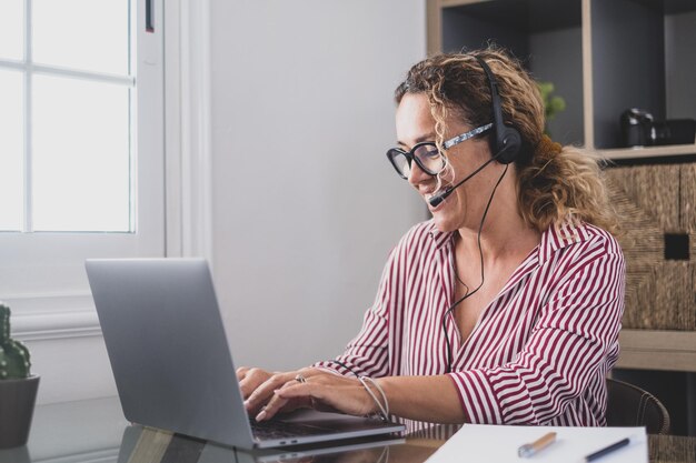 Foto jonge vrouw die thuis een laptop gebruikt