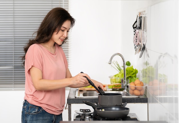 Jonge vrouw die thuis eten bereidt
