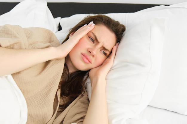 Foto jonge vrouw die thuis op bed slaapt.