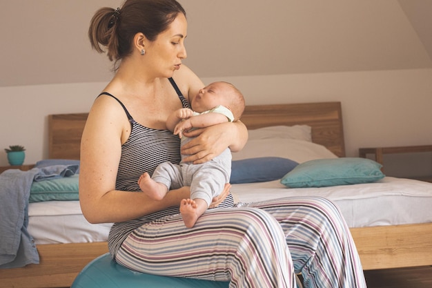 Foto jonge vrouw die thuis op bed zit.