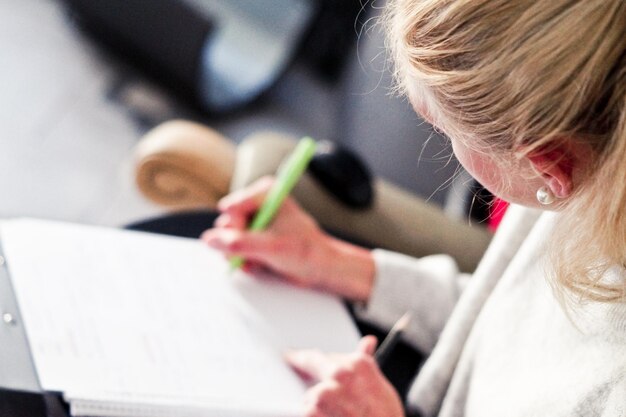 Foto jonge vrouw die thuis op papier schrijft