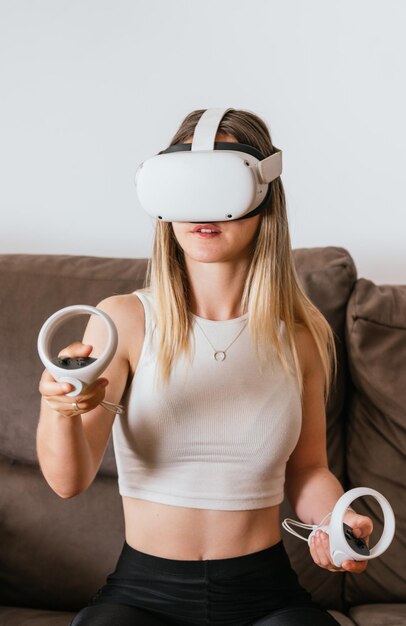 Jonge vrouw die thuis virtual reality-spellen speelt