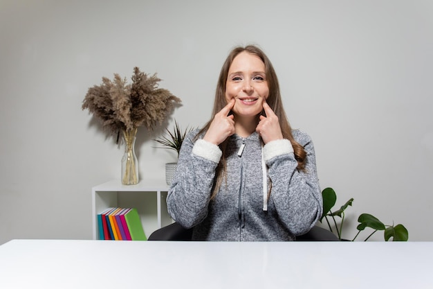 Jonge vrouw die thuis werkt met webcameraweergave