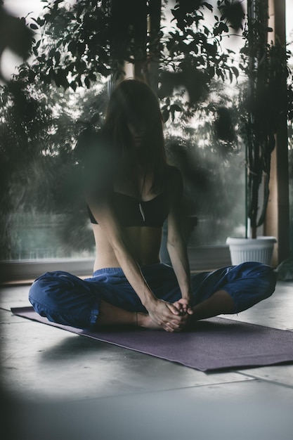 Foto jonge vrouw die thuis yoga doet