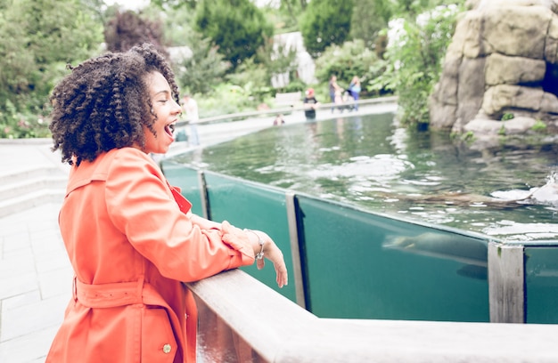 Jonge vrouw die van de show genieten bij de dierentuin met zeeleeuwen