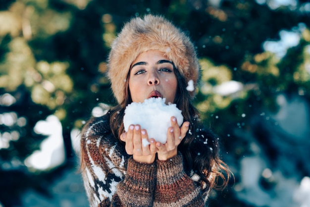 Jonge vrouw die van de sneeuwbergen in de winter geniet