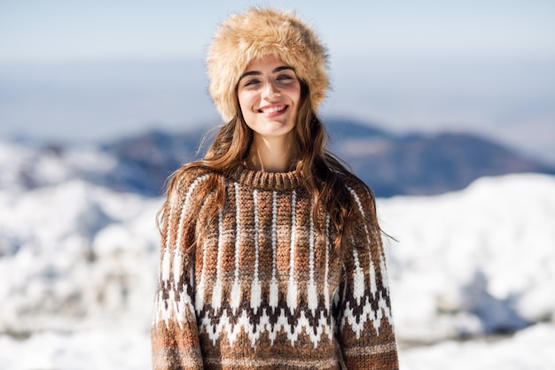 Jonge vrouw die van de sneeuwbergen in de winter geniet
