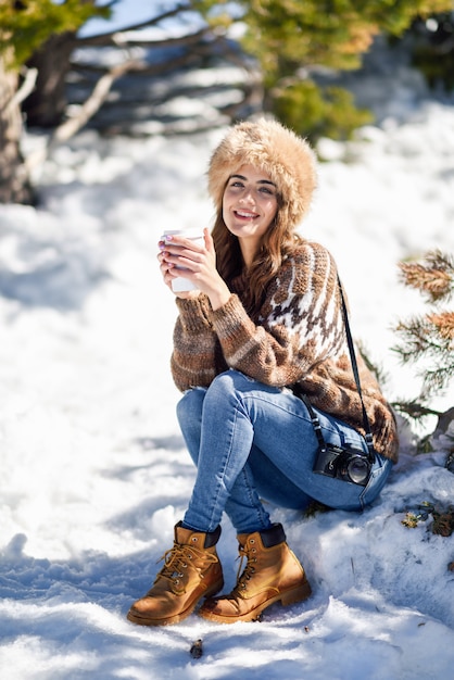 Jonge vrouw die van de sneeuwbergen in de winter geniet