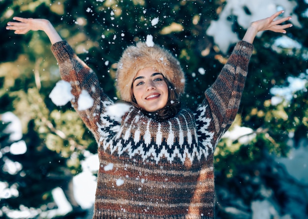 Jonge vrouw die van de sneeuwbergen in de winter geniet