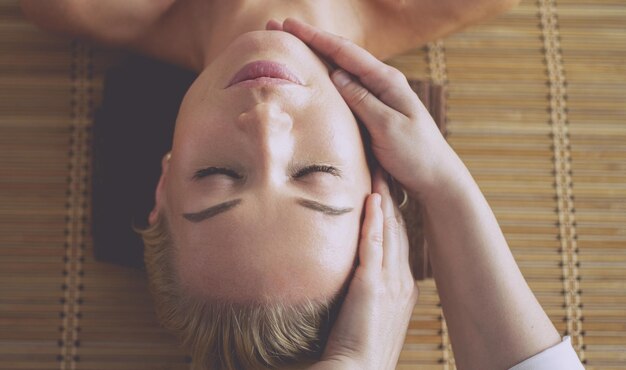 Foto jonge vrouw die van massage in kuuroordsalon geniet