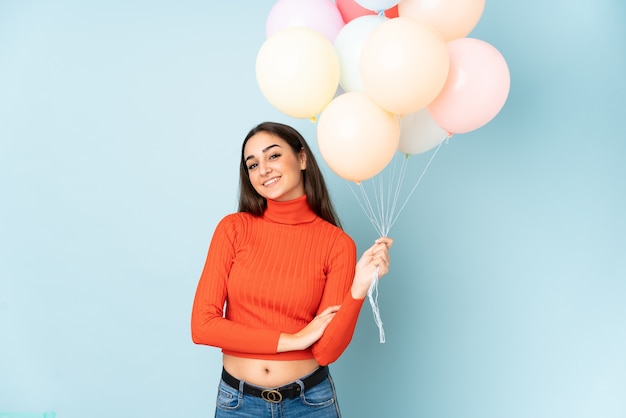 Jonge vrouw die veel ballons vangt