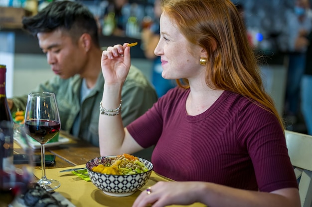 Jonge vrouw die veganistische en gezonde salade eet in restaurant, concept van duurzaamheid en groene levensstijl, vegetarisch dieet voor gezondheidszorg en gewichtsbeheersing