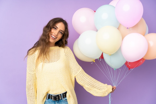 Jonge vrouw die vele ballons opvangt