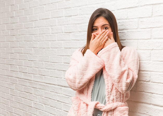 Jonge vrouw die verrast en geschokt pyjama draagt