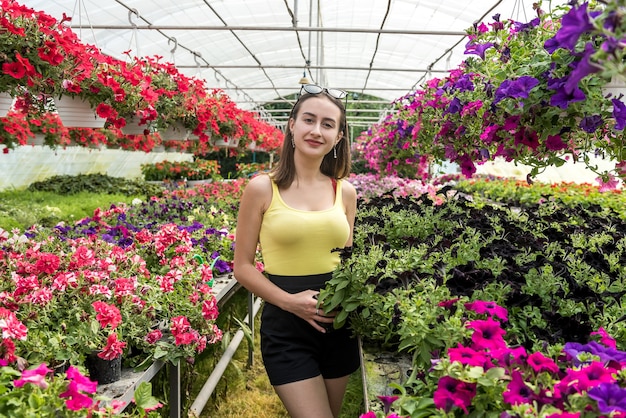 Jonge vrouw die voor bloemen zorgt