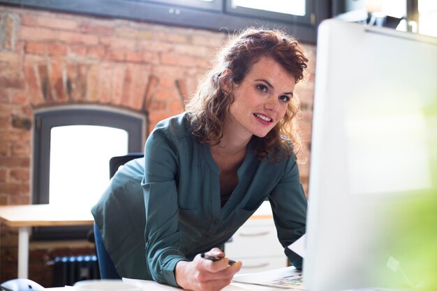 Jonge vrouw die werkt aan een bureau in een modern kantoor