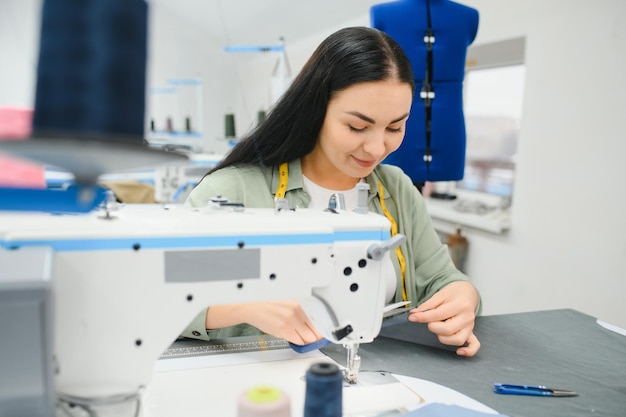 Jonge vrouw die werkt als naaister in kledingfabriek