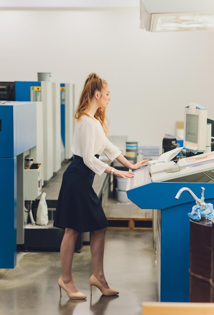 Jonge vrouw die werkt in drukkerij Drukpers