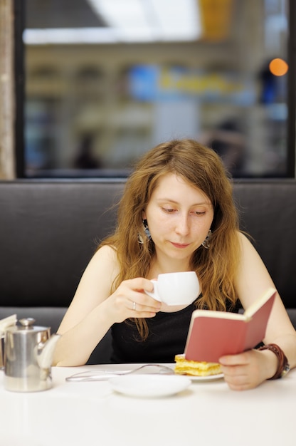 Jonge vrouw die werkt in een café