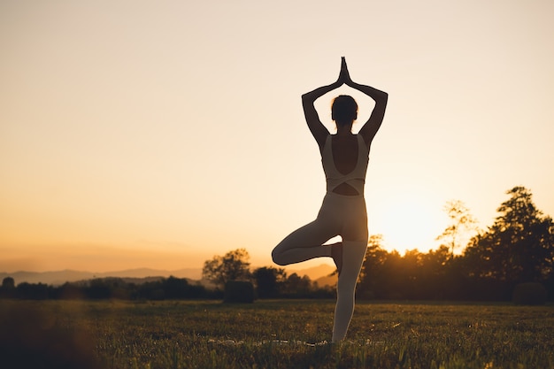 Foto jonge vrouw die yoga beoefent op de natuur meisje mediteert buitenshuis