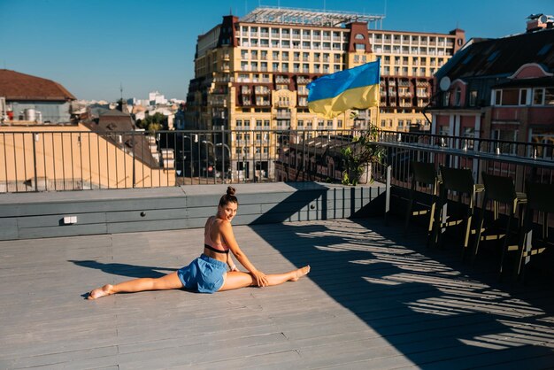 Jonge vrouw die yoga beoefent op het dak van een gebouw