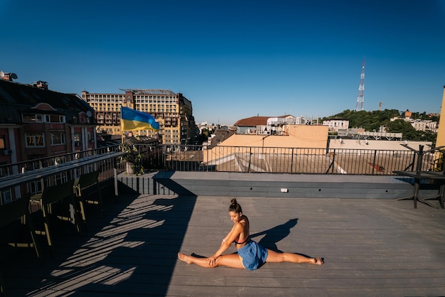 Jonge vrouw die yoga beoefent op het dak van een gebouw