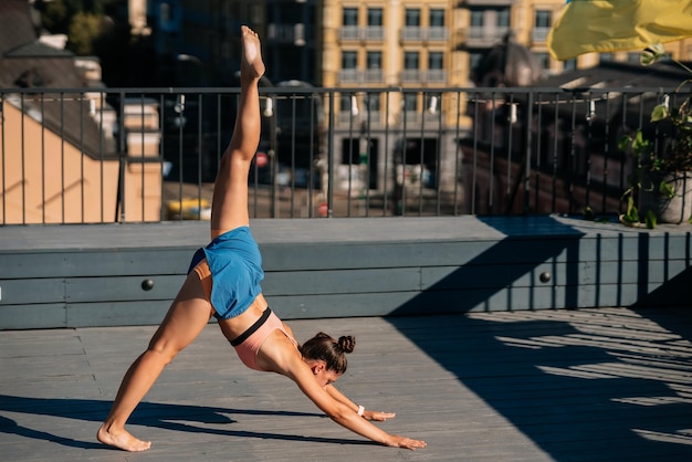 Jonge vrouw die yoga beoefent op het dak van een gebouw