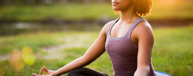 jonge vrouw die yoga beoefent tegen een levendige zonsondergang die vrijheid en welzijn belichaamt in de natuur