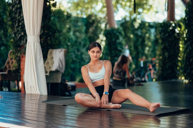 Jonge vrouw die yoga beoefent Voert een oefening uit