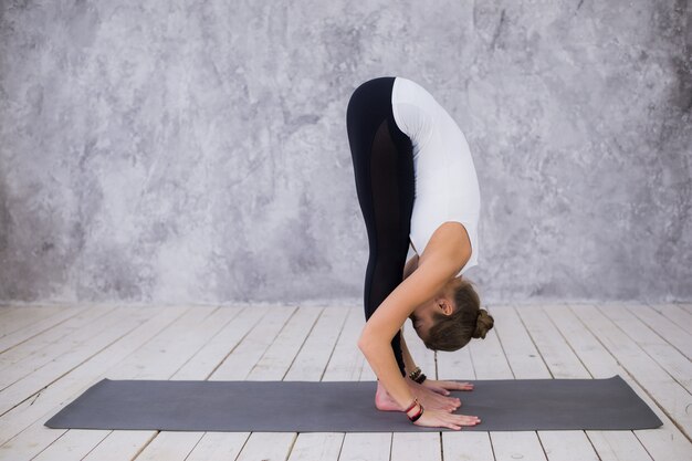 Foto jonge vrouw die yoga binnen doet