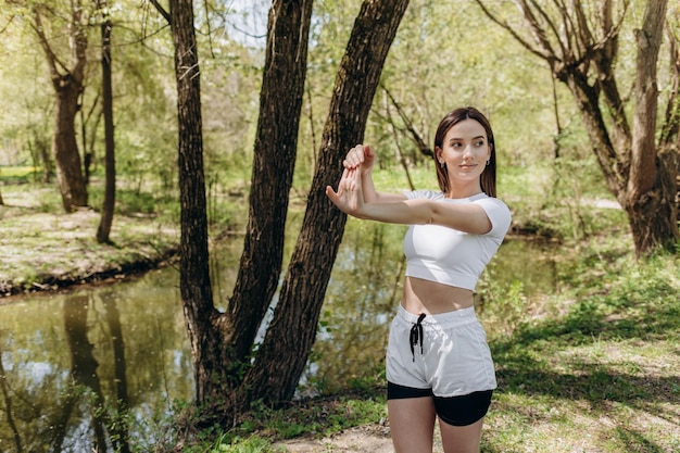 Jonge vrouw die yoga in ochtendpark doet