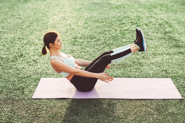 Jonge vrouw die yoga in stadion doet