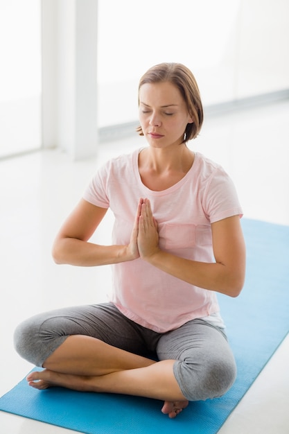 Jonge vrouw die yoga vormt