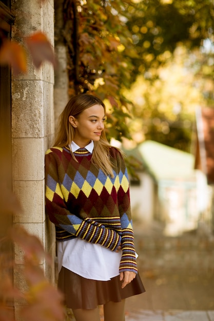 Foto jonge vrouw die zich buiten bij zonnige de herfstdag bevindt