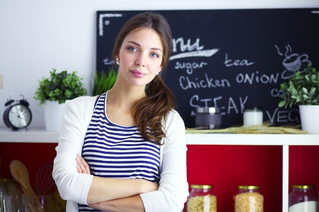 Jonge vrouw die zich dichtbij bureau in de keuken bevindt