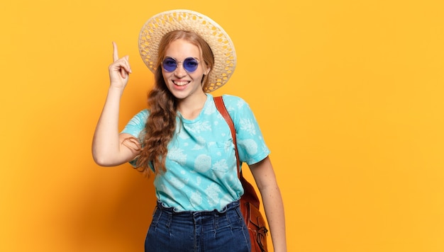 Jonge vrouw die zich een gelukkig en opgewonden genie voelt na het realiseren van een idee, vrolijk vinger opstekend, eureka!