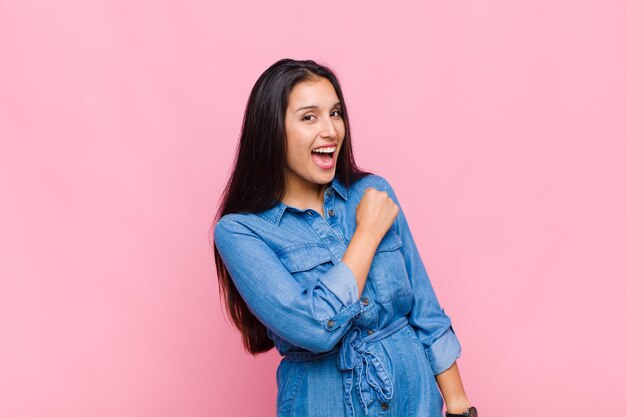 Jonge vrouw die zich gelukkig, positief en succesvol voelt, gemotiveerd wanneer ze voor een uitdaging staat of goede resultaten viert