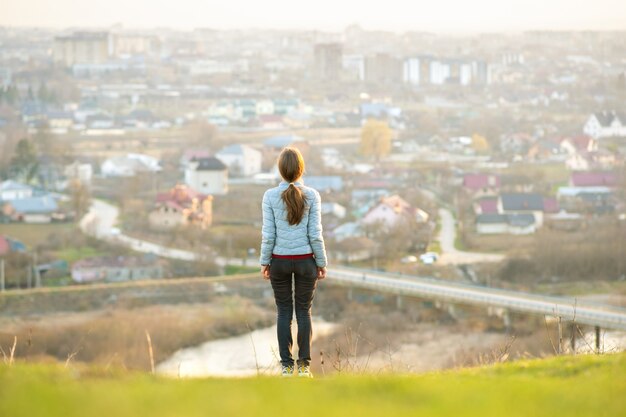 Jonge vrouw die zich in openlucht geniet van stadsmening